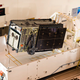 A satellite roughly the same size as Space Vehicle Four is loaded into a transport container.